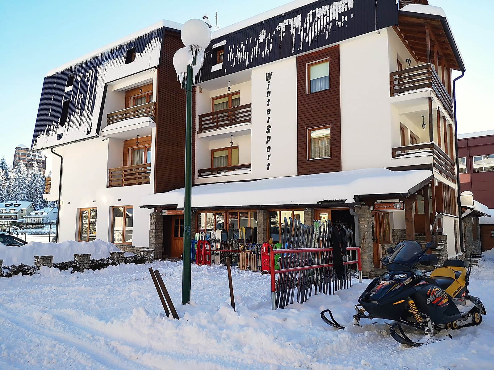 Objekat Apartmana WinterSport na Babanovcu pod dubokim snijegom, ispred ulaza stalak sa skijama